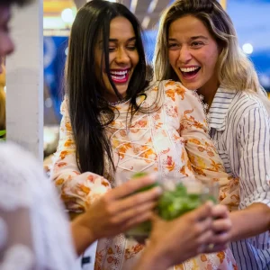 Happy girls having fun cheering with cocktails at bar on the beach, nightlife and luxury lifestyle Happy girls having fun cheering with cocktails at bar on the beach, nightlife and luxury lifestyle